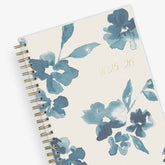 academic weekly monthly planner featuring a white background and blue paint brush florals, twin wire-o binding in a 5x8 planner size for the school year july 2025 - june 2026