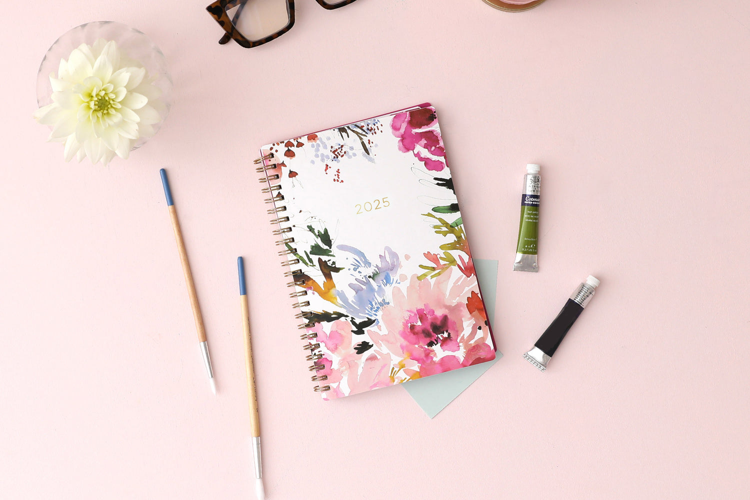 The kelly ventura 2025 weekly monthly planner for blue sky features beautiful watercolored floral cover with gold twin wire-o binding in a 5x8 planner size.