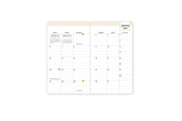 2025 planner featuring a weekly spread with lined writing space, bullet points, and monthly white tabs with gold text.