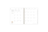 2025 planner featuring a monthly spread with lined writing space, bullet points, and monthly white tabs with black text.
